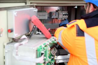 Électricien qui contrôle un tableau électrique selon la nouvelle norme