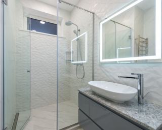 Salle de bain avec douche, lavabo et éclairage étanche